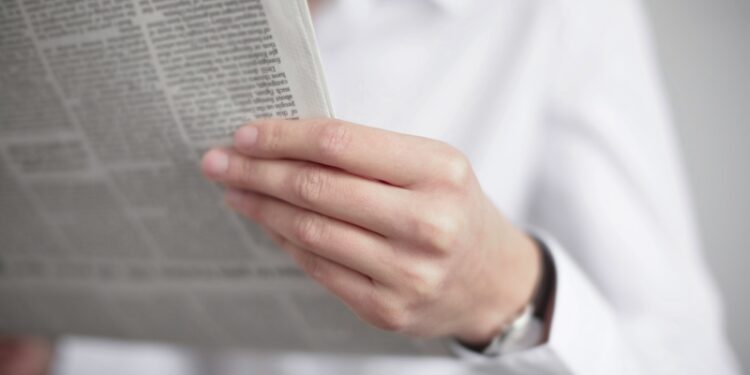 Un hombre lee un periódico en una imagen de archivo.