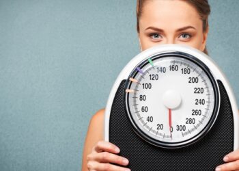 Una mujer sujeta una báscula. FOTO: Berbés Asociados.