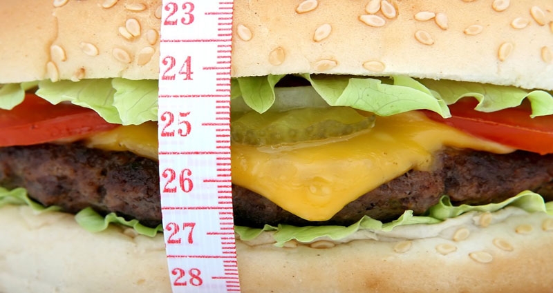 Una hamburguesa y una cinta de medir en una imagen de archivo.