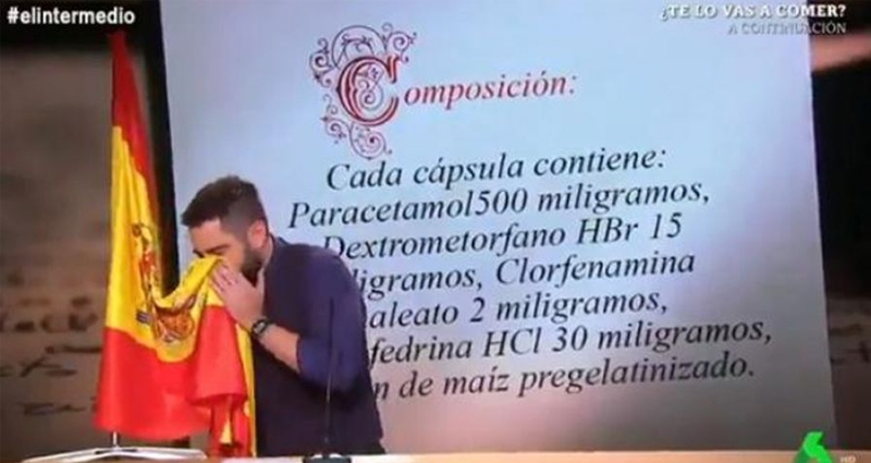 Dani Mateo sonándose la nariz con la bandera de España