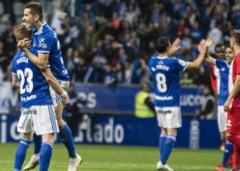Los jugadores del Real Oviedo celebran ante la mirada de los integrantes del Granada