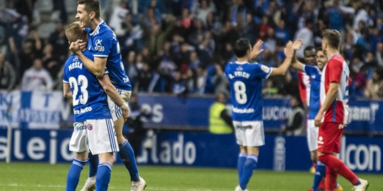 Los jugadores del Real Oviedo celebran ante la mirada de los integrantes del Granada