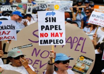 A woman holds up a sign reading "No paper, no jobs", during a protest by newspaper workers and opposition parties to demand from the government U.S. dollars at a prime rate to buy paper for their publications, in Caracas February 11, 2014. Newspaper owners claim they are close to running out of their stock of paper due to the lack of dollars to import it, local media said.  REUTERS/Carlos Garcia Rawlins (VENEZUELA - Tags: POLITICS CIVIL UNREST MEDIA BUSINESS EMPLOYMENT)